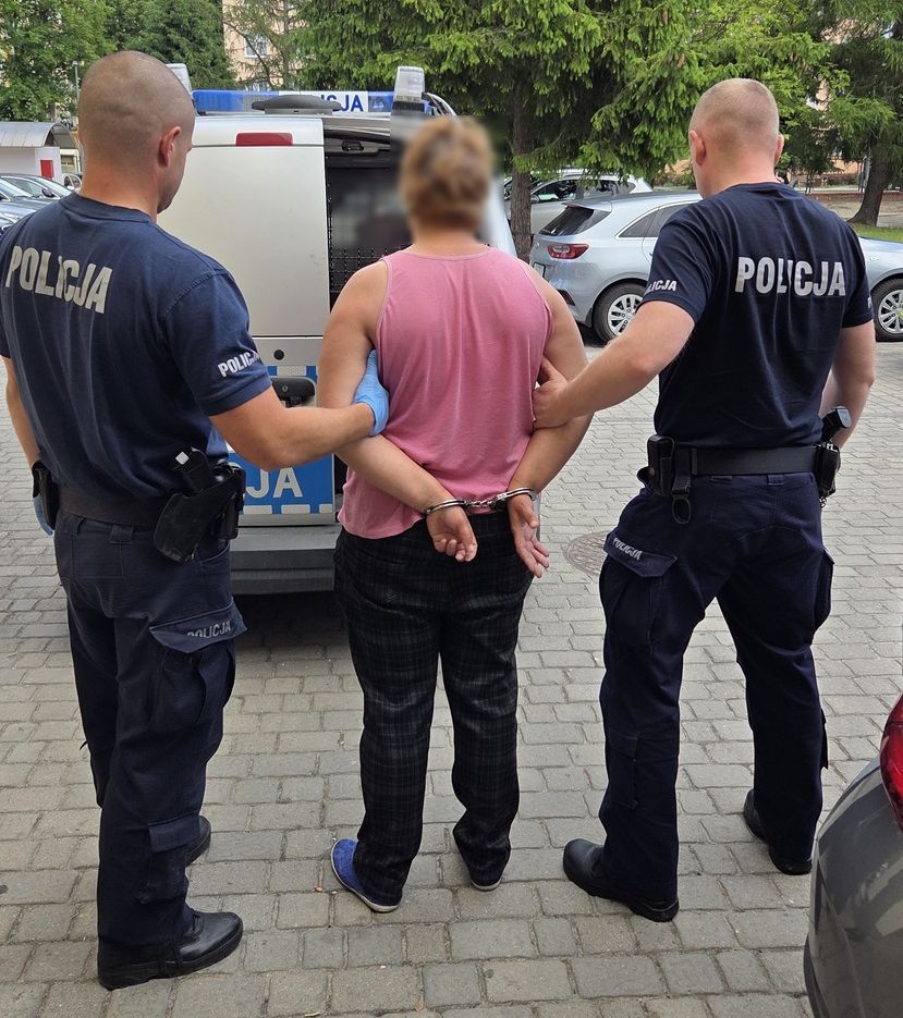 policjanci prowadzą zatrzymaną kobietę