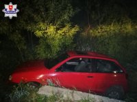 zdjęcie samochodu, którym pijany kierowca zjechał z drogi i utknął pomiędzy drzewem a przepustem