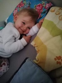 małe dziecko lezy na łóżku