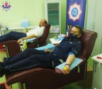 zdjecie przedtawia policjanta oddajacego krew