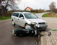 zdjęcie na pierwszym planie przedstawia samochod osobowy marki opel koloru srebrnego wraz z motocyklem koloru zielonego ktore braly udzial w zdarzeniu drogowym w skrobowie
