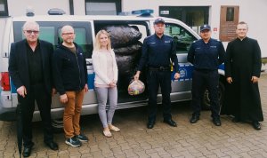 zdjęcie przedstawia policjantów przekazujących nakrętki dla hospicjum
