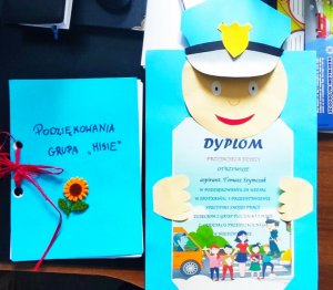 zdjęcie przedstawia dyplom wykonany przez dzieci i podarowany dzielnicowemu