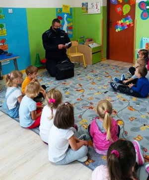 zdjecie przedstawia dzielnicowego który prowadzi zajęcia z dziecmi