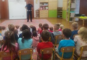 zdjęcie przedstawia policjanta wydziału ruchu drogowego który prowadzi zajęcia z dziecmi z przedszkola