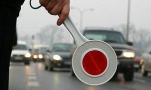 zdjecie przedstawia  urządzenie do zatrzymywania samochodów, tak zwany lizak policyjny trzymany w dłoni