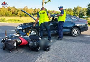 zdjecie przedstawia policjantów wykonujących czynności podczas zdarzenia drogowego