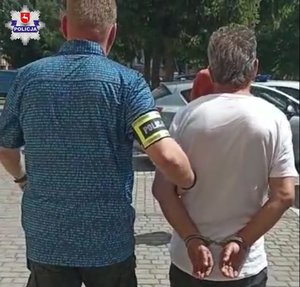 zdjęcie przedstawia policjanta operacyjnego który prowadzi właściciela psów