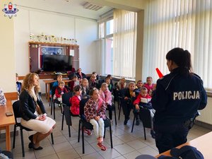 zdjęcie przedstawia dzieci i policjantkę, która prowadzi zajęcia