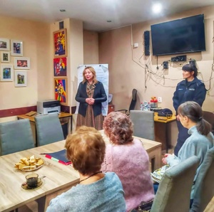 na zdjęciu dyrektor Ośrodka z policjantką  w tle seniorzy