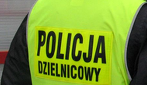na zdjęciu policjant stojący tyłem z napisem policja dzielnicowy