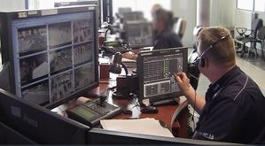 na zdjęciu policjant dyżurny ze słuchawkami na głowie