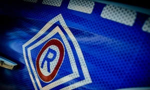 na zdjęciu znaczek wydziału ruchu drogowego biały na niebieskim tle