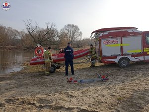 na zdjęciu łódz poszukiwawcza, policjant i strażacy