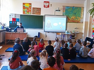 na zdjęciu policjanci z dziećmi w sali szkolnej