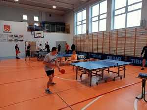 na zdjęciu policjanci biorący udział w turnieju i stoły do tenisa stołowego