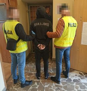 na zdjeciu dwóch policjantów doprowadza zatrzymanego za pobicie