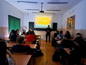 na zdjęciu policjant stojący przed uczniami w szkole