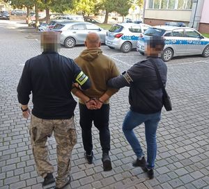 zatrzymany mężczyzna w asyście policjantów