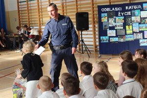 na zdjęciu dzieci i policjant oraz pedagog na rozstrzygnięciu konkursu