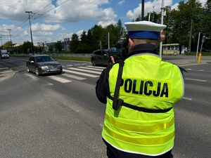 na zdjęciu policjant kontrolujący prędkość pojazdów