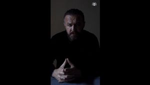 na zdjęciu siedzący meżczyzna