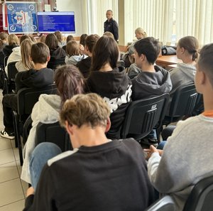 na zdjeciu uczniowie i policjant