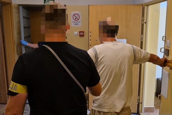Policjant prowadzi zatrzymanego