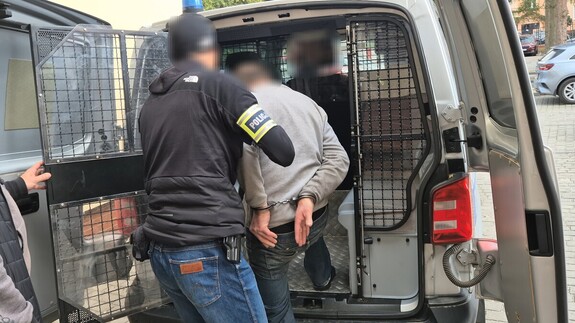 Policjant prowadzi zatrzymanego