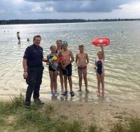 policjant z uczestnikami akcji