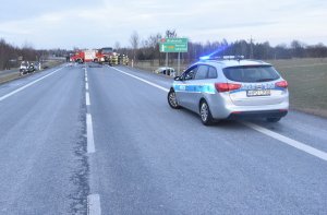 radiowóz stojący na ulicy, w tle widać miejsce wypadku