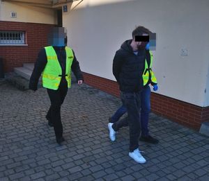 policjanci prowadzą zatrzymanego