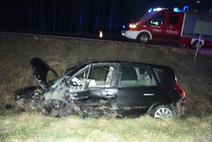 czarny pojazd w rowie. W tle pojazd strażaków