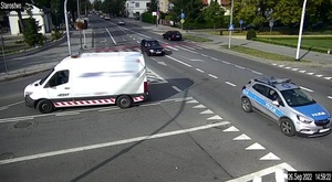 Na zdjęciu widzimy jak policjanci pilotują auto z rannym dzieckiem do szpitala.