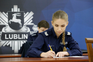 policjantka siedzi przy stole i rozwiązuje test
