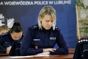 policjantka siedzi przy stole i rozwiązuje test